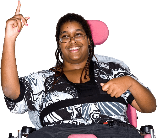 A woman in a wheelchair, smiling and raising her hand to say something