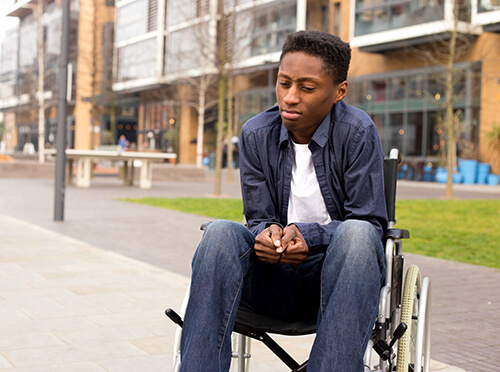 A young man in a wheelchair looking stressed
