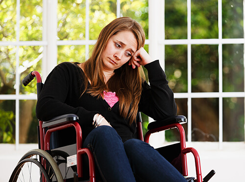 A woman in a wheelchair looking sad