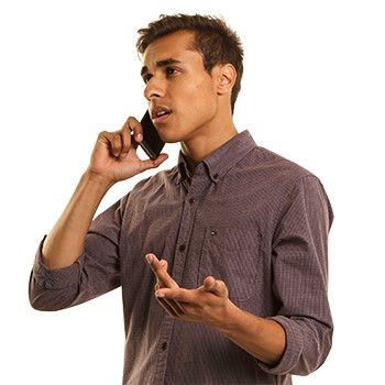 A young man talking on the phone, looking frustrated