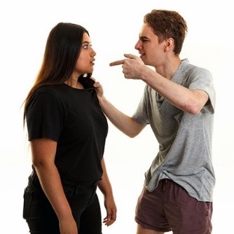 A man aggressively pointing and yelling at a woman