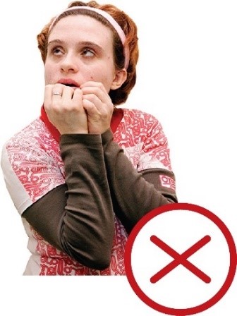 A woman looking scared with her hands on her mouth. There is a cross next to the image.