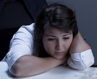 A woman looking sad with her head in her hands