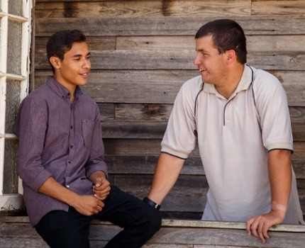 2 men talking and smiling