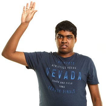 A young man putting his hand up to say something