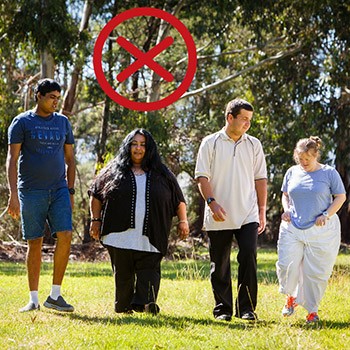 A group of friends walking together in a park with a cross above them.